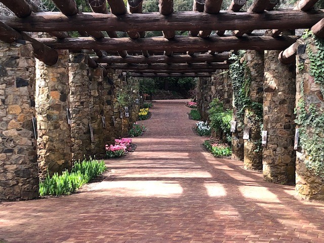 Araluen Botanical Park Pergola made in the 1930s with granite and jarrah pillars with flowers planted one side