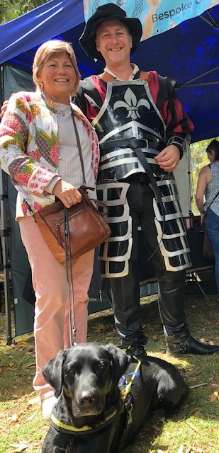 PIcture of Colleen at the Medieval festival of Guildford,standing next to a smiling gentleman with a re-white costume on.