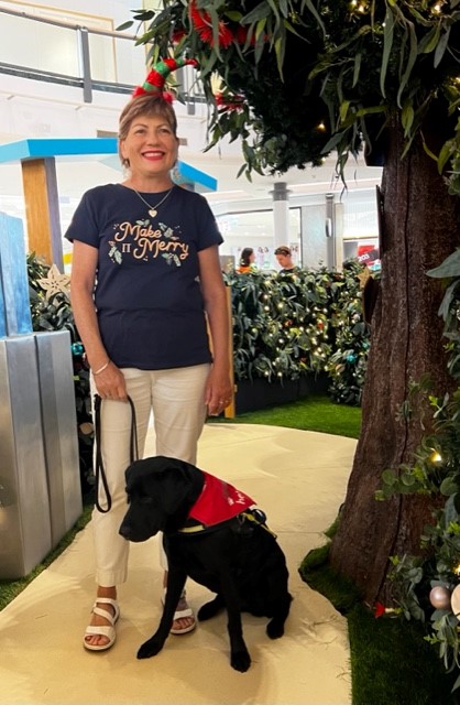 Colleen Ashby and seeing eye dog Rhian in a christmas gift centre.