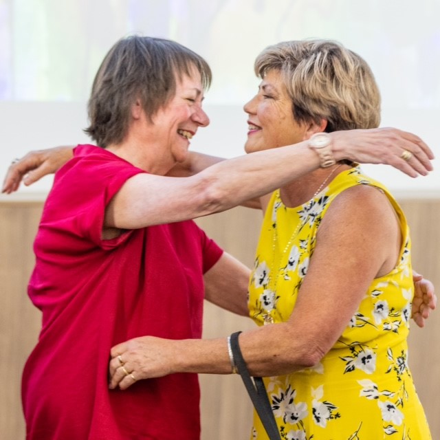 Editor Claudette Pope and Colleen hugging on stage at the book launch.