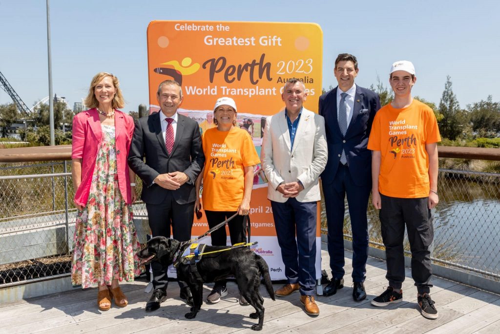 Picture of celebreties and Colleen and Rhian in front of billboard saying "Greatest Gift Perth 2023".