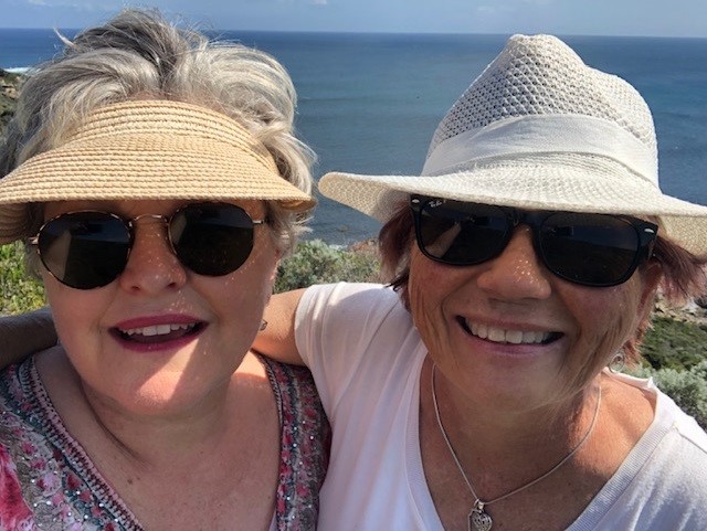 A picture of Deb and Colleen whale watching with hats on and smiling.