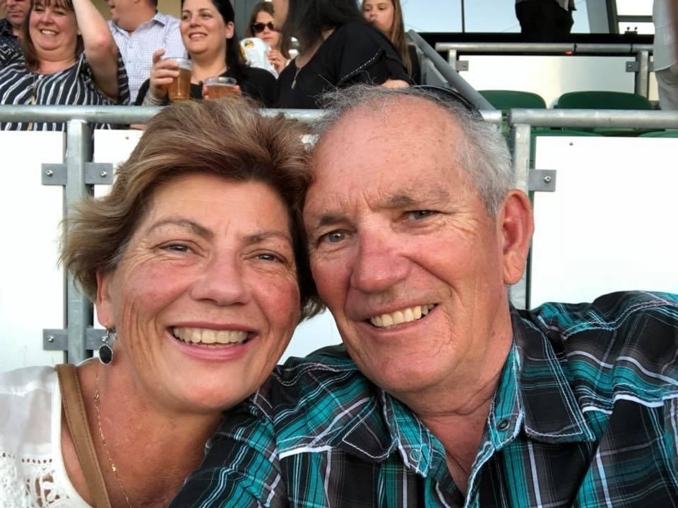 Lovely picture of Colleen and her husband close together and smiling to the camera.